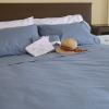 SleepFROG blue sheet set on bed with brown headboard